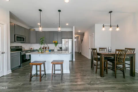 a kitchen with a dining table chairs stainless steel appliances and kitchen view
