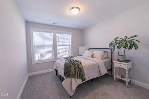 a bed sitting in a bedroom next to a window