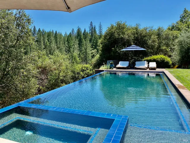 a view of a backyard with a table and chair under an umbrella