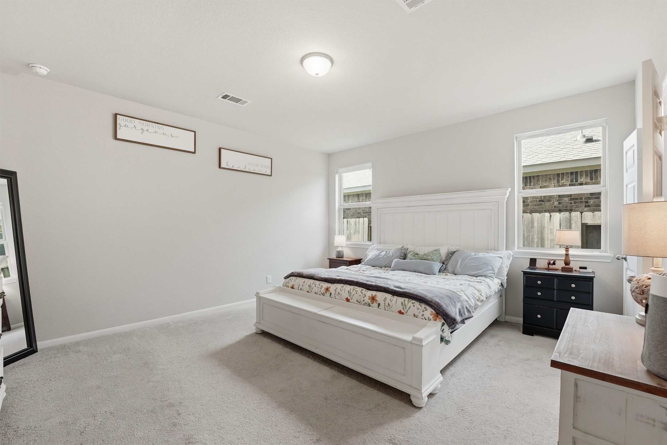 2130 Shellbark Way La Marque, TX 77568 - Photo 11 of 30 Spacious primary bedroom with neutral tones, ample natural light from two windows, and a cozy carpet.