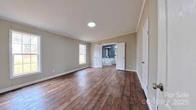a view of a room with wooden floor and a window