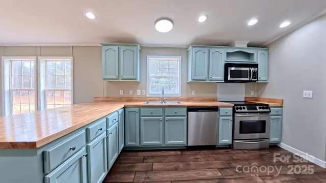 a kitchen with stainless steel appliances granite countertop a stove a sink and a microwave