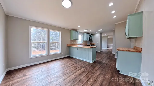 a open kitchen with kitchen island a sink dishwasher stove with wooden floors and a fireplace