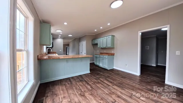 a kitchen view with wooden floor and a window