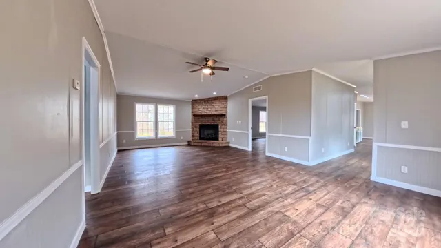 a view of a livingroom with wooden floor and a ceiling fan