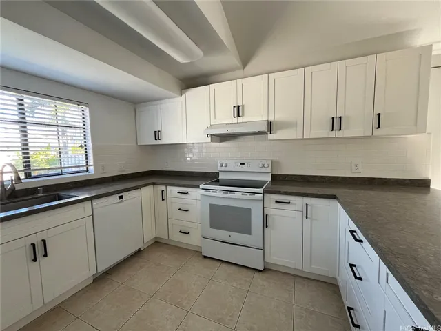 a kitchen with granite countertop white cabinets white stainless steel appliances with a sink and dishwasher
