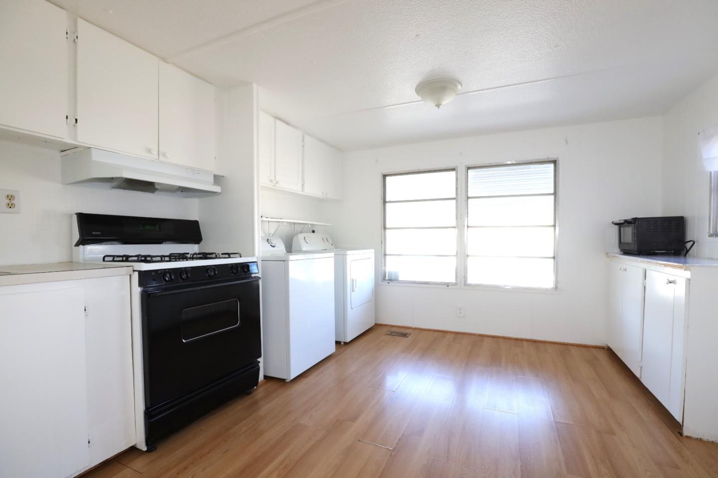 60 Wilson Way, Unit 70 Milpitas, CA 95035 - Photo 6 of 20 a kitchen with wooden floors and white appliances