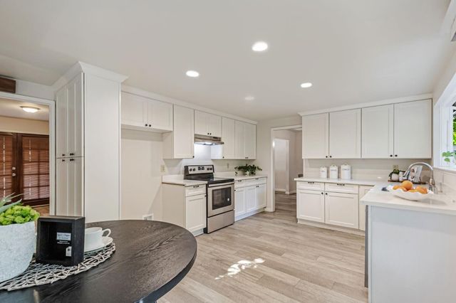 a kitchen with a stove sink and cabinets