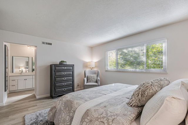 a bedroom with a bed and dresser with mirror