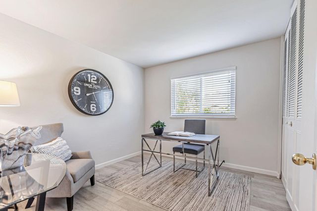 a living room with a table chairs and a window