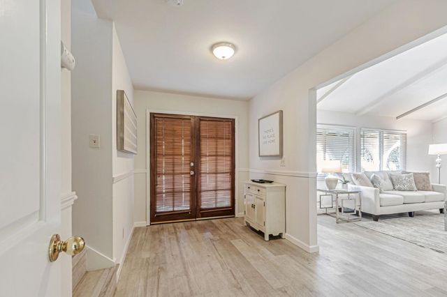 a view of a livingroom with a furniture wooden floor and windows