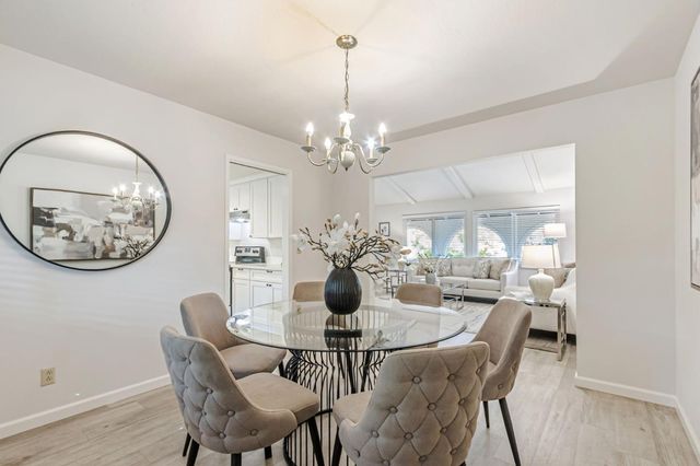 a view of a dining room with furniture and chandelier