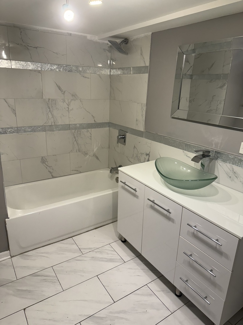 7806 South Rhodes Avenue Chicago, IL 60619 - Photo 13 of 29 a bathroom with a sink and a mirror