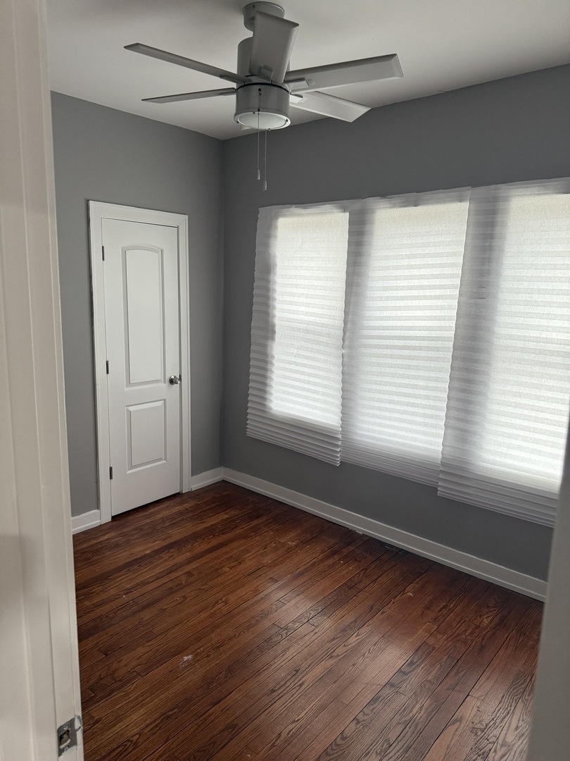 7806 South Rhodes Avenue Chicago, IL 60619 - Photo 25 of 29 a view of an empty room with wooden floor and a window