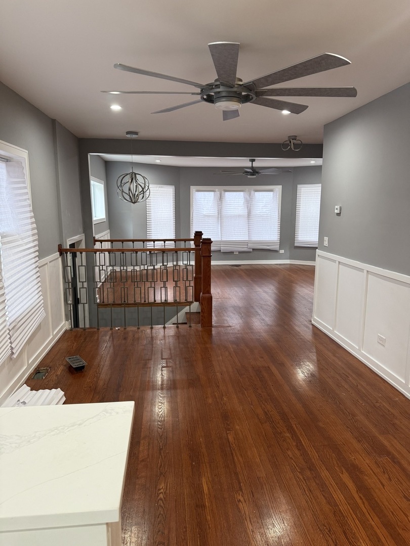 7806 South Rhodes Avenue Chicago, IL 60619 - Photo 3 of 29 a view of a livingroom with wooden floor and stairs