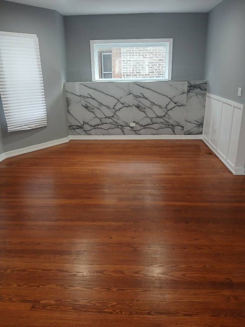 7806 South Rhodes Avenue Chicago, IL 60619 - Photo 6 of 29 a view of a room with wooden floor and window