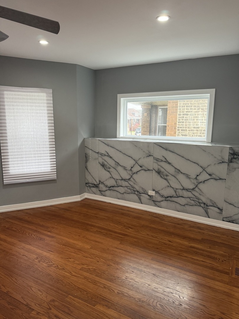 7806 South Rhodes Avenue Chicago, IL 60619 - Photo 10 of 29 an empty room with wooden floor and windows