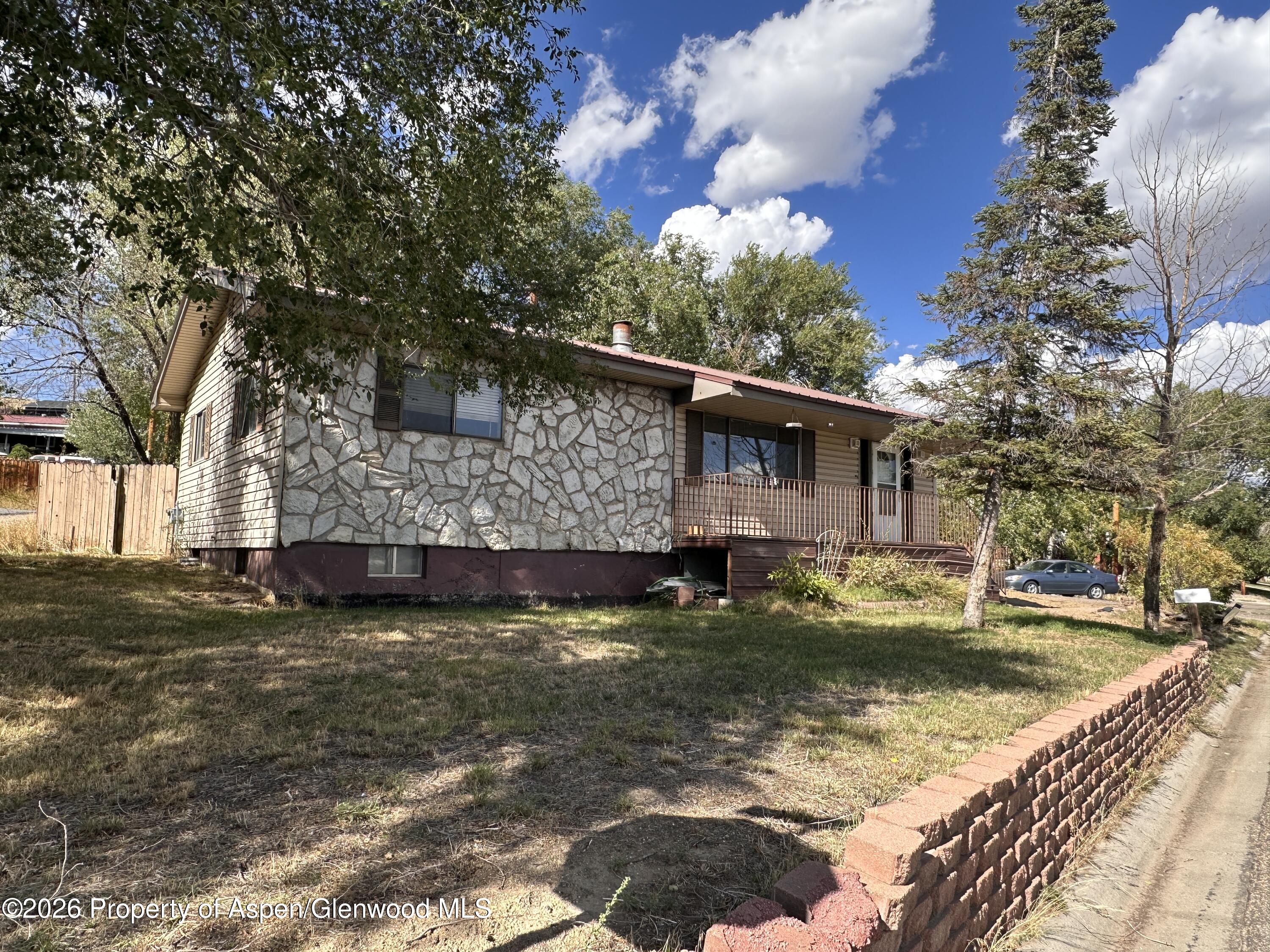 1903 Frontier Drive Craig, CO 81625 - Photo 1 of 16 a view of a house with a big yard and a large tree