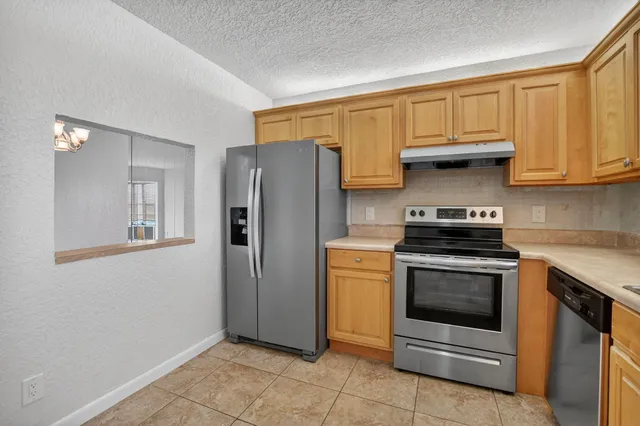 a kitchen with stainless steel appliances granite countertop a stove a refrigerator and a sink