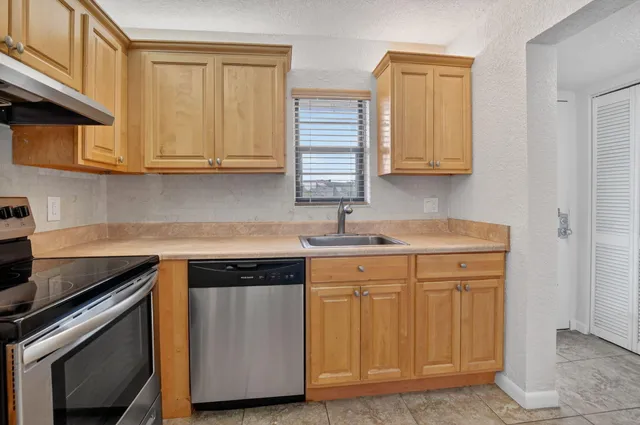 a kitchen with stainless steel appliances granite countertop a sink stove and cabinets