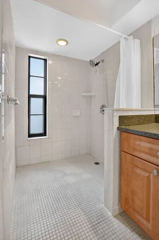 a spacious bathroom with a granite countertop sink and a toilet