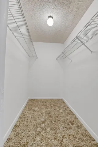 an empty room with cabinet and windows