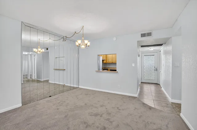 a view of a hallway with wooden floor and a chandelier