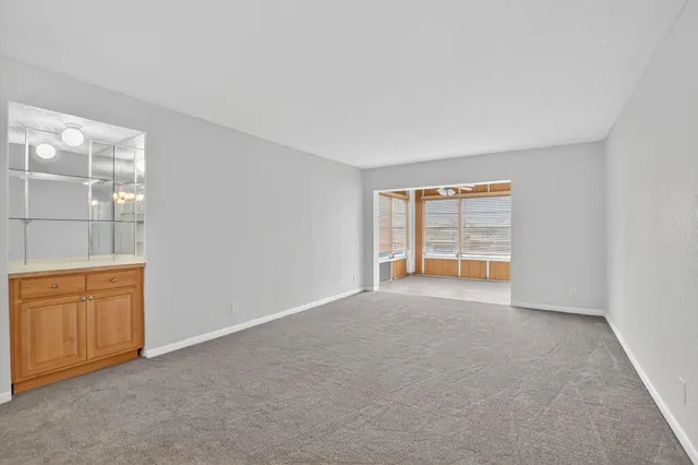a view of an empty room with window and cabinet