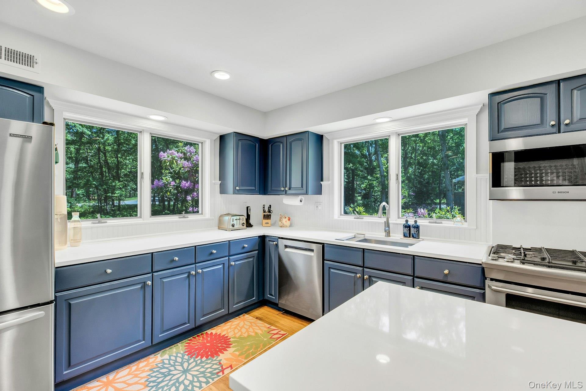 16 Hildreth Road Hampton Bays, NY 11946 - Photo 11 of 29 a kitchen with wooden cabinets a sink a stove a refrigerator and a window