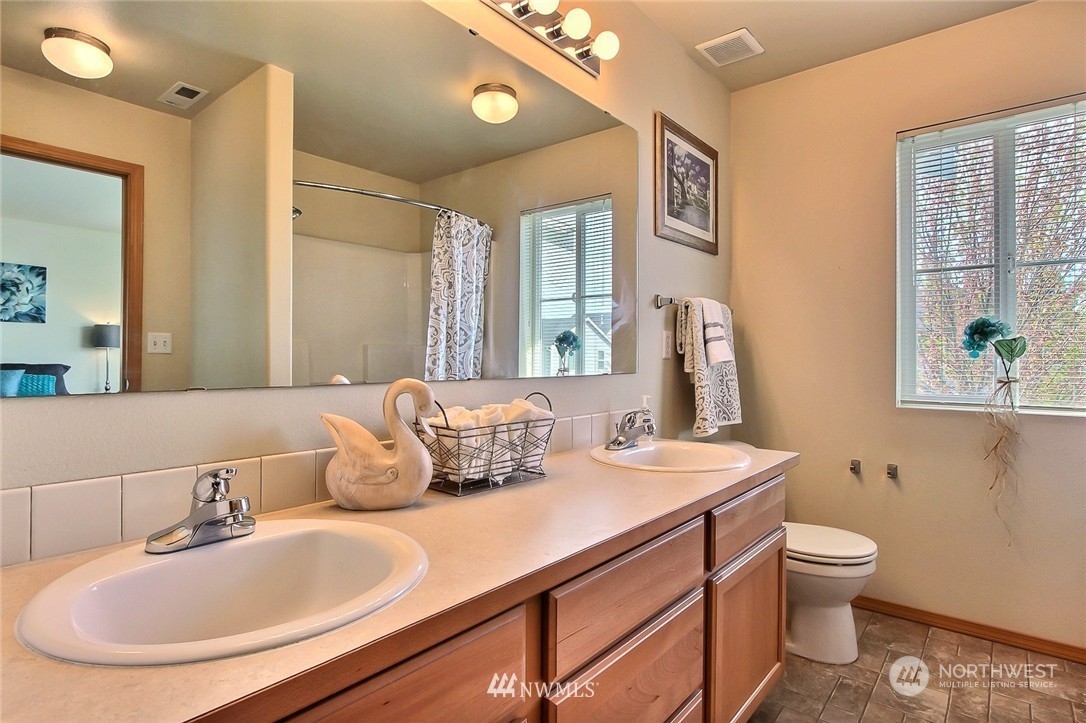 2280 Simmons Street, Unit A DuPont, WA 98327 - Photo 16 of 25 a bathroom with a granite countertop sink mirror and toilet