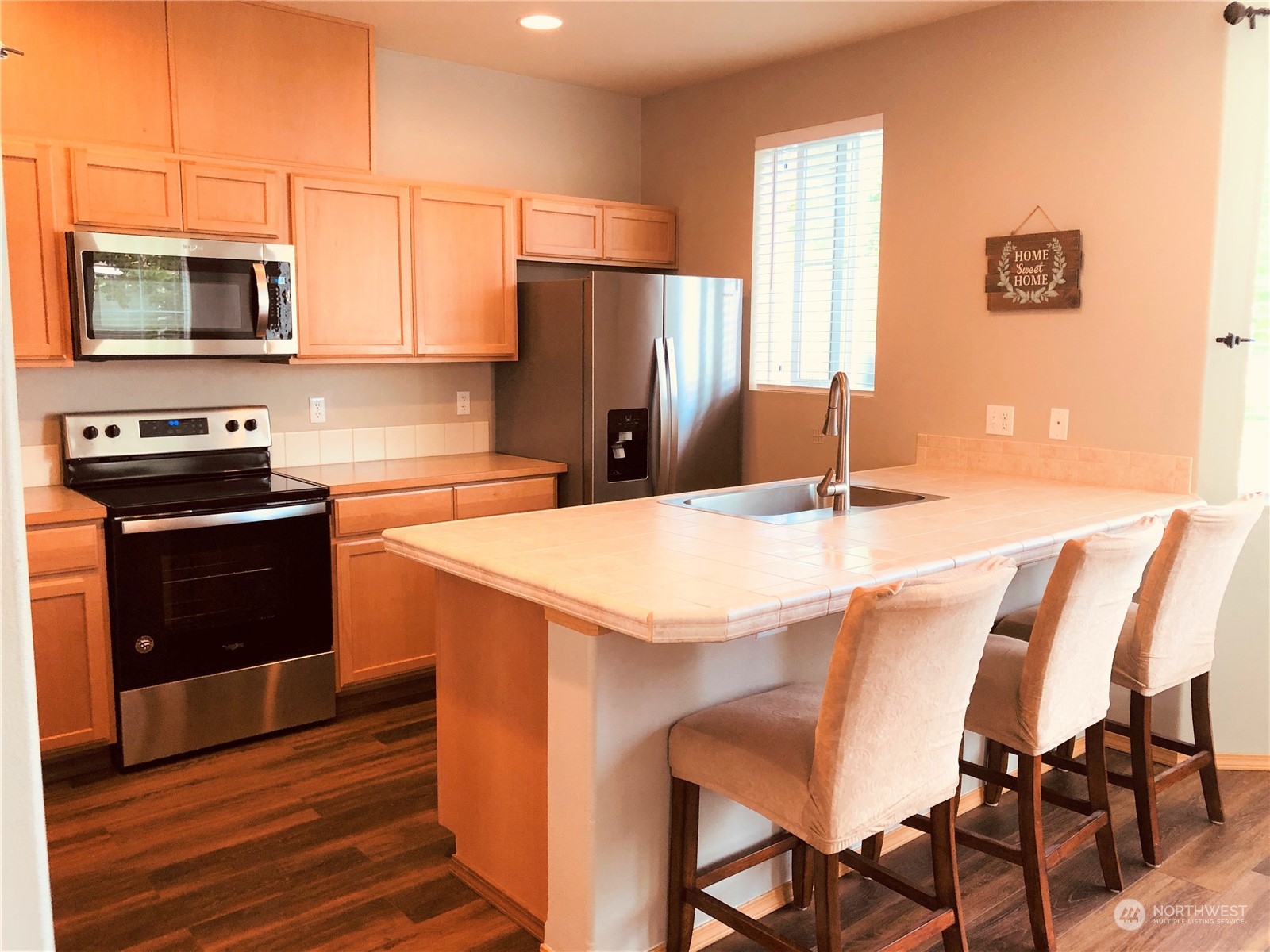 2280 Simmons Street, Unit A DuPont, WA 98327 - Photo 9 of 25 a kitchen with stainless steel appliances kitchen island a table chairs microwave and sink