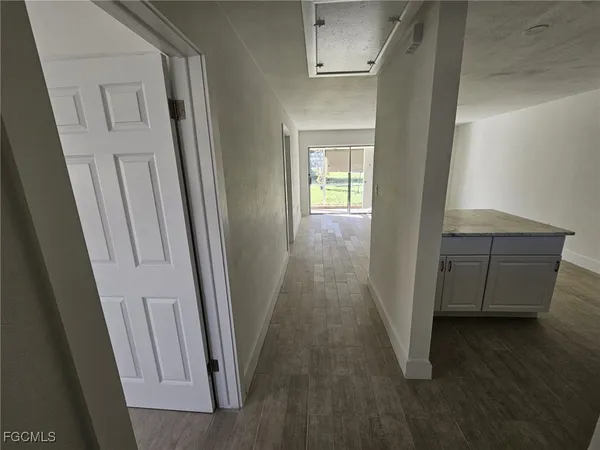 a view of a hallway and wooden floor in a room