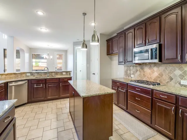 a kitchen with granite countertop a sink counter top space appliances and cabinets