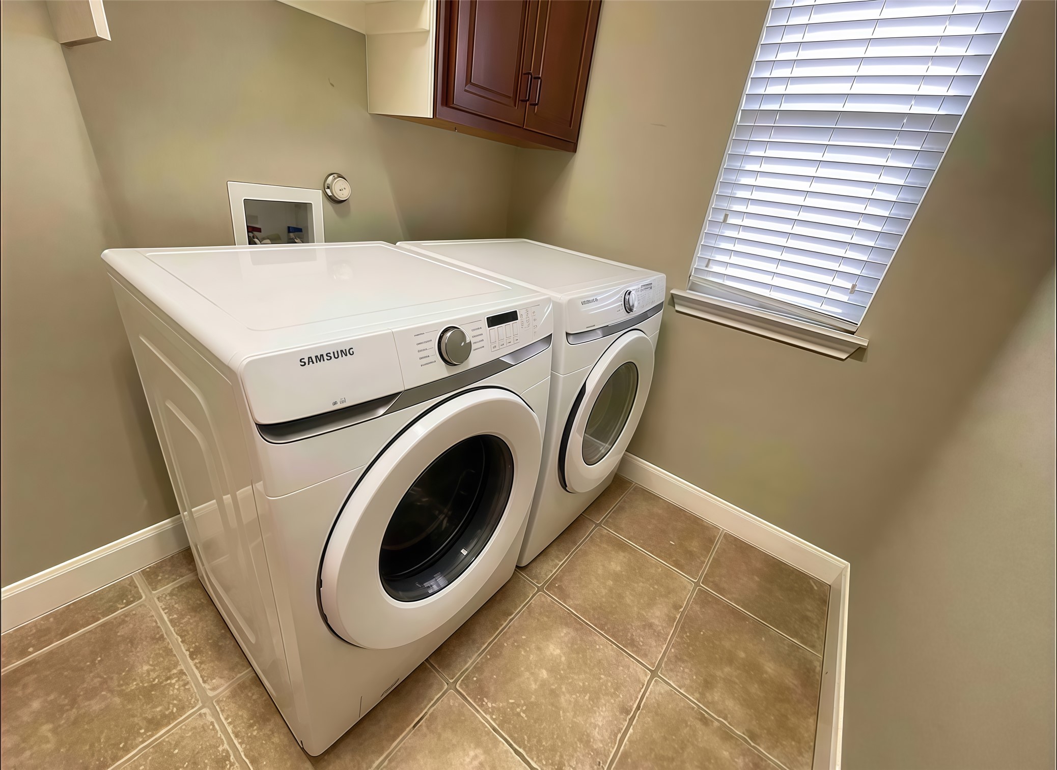 12616 Alberta Ridge Trail Austin, TX 78726 - Photo 12 of 26 Functional tile flooring and overhead cabinetry define this dedicated laundry space.