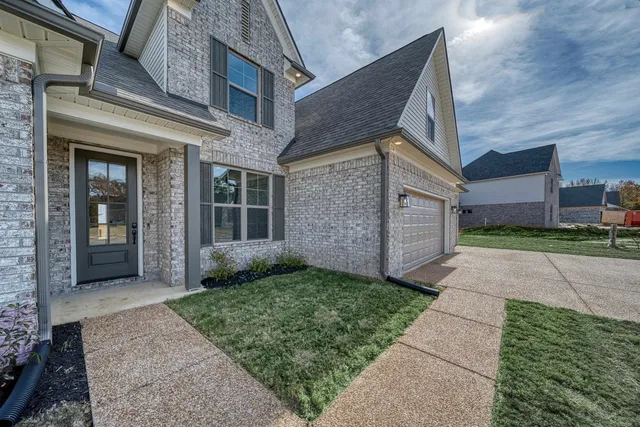 a view of a brick house with a yard