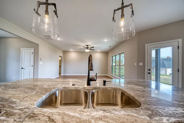 a large kitchen with kitchen island a large counter space a sink appliances and cabinets