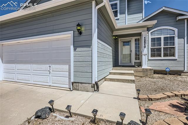 12510 Motley Road Peyton, CO 80831 - Photo 3 of 36 View of exterior entry featuring a garage