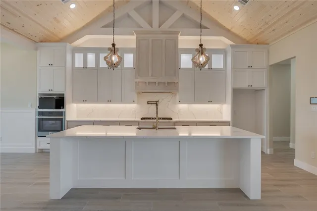 a kitchen with stainless steel appliances granite countertop a sink a stove and cabinets