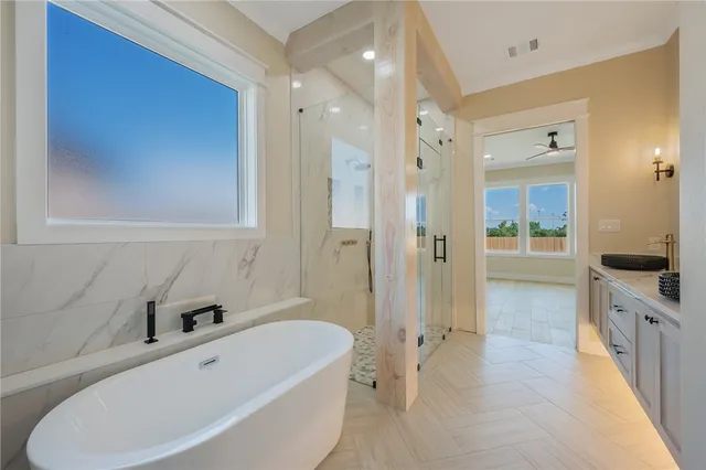 a bathroom with a tub sink shower and mirror