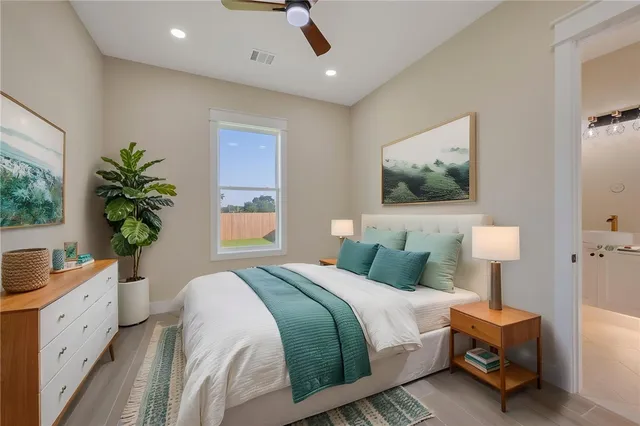 a bedroom with a large bed and a potted plant