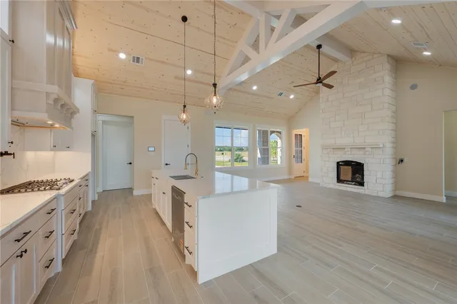 an open kitchen with a stove fireplace and wooden floor
