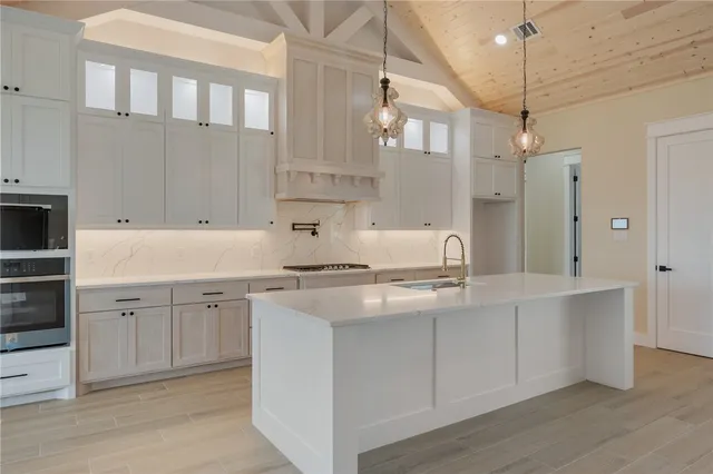 a kitchen with white cabinets and sink