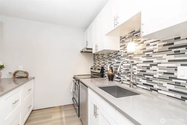 a kitchen with a sink stove and cabinets
