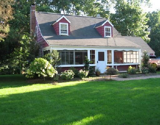 a view of a house with a yard and sitting area