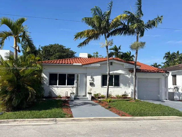 a front view of a house with plants and garage
