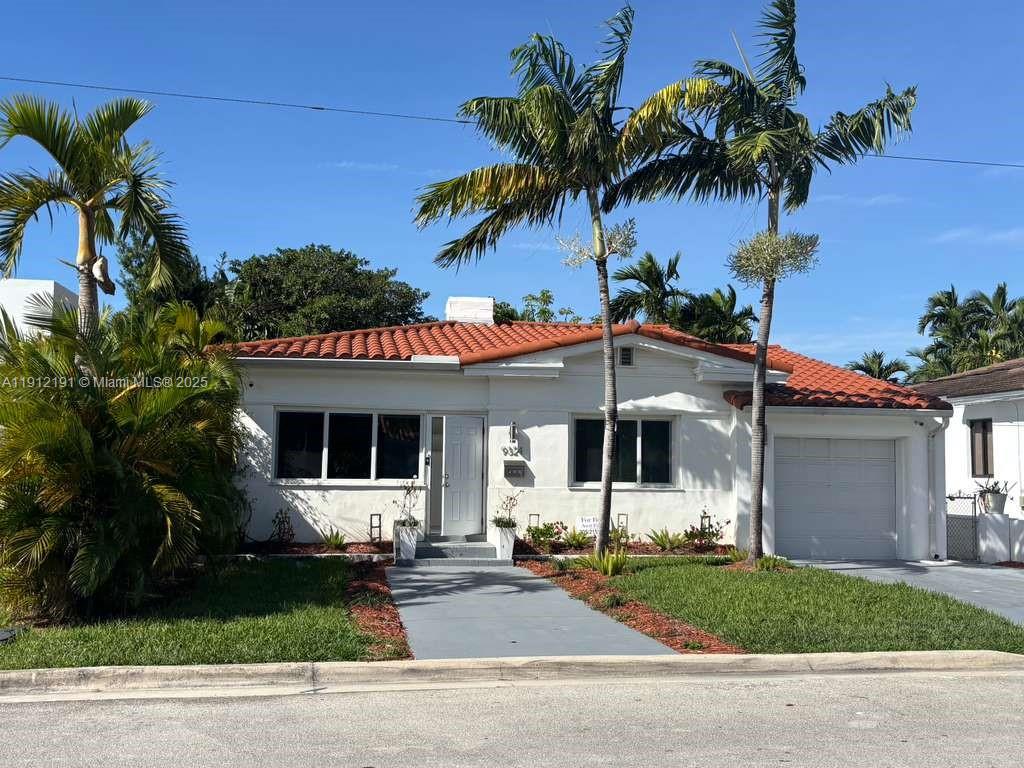 a front view of a house with plants and garage