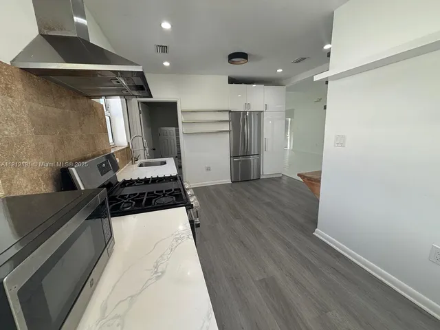 a kitchen with stainless steel appliances a refrigerator and a stove top oven