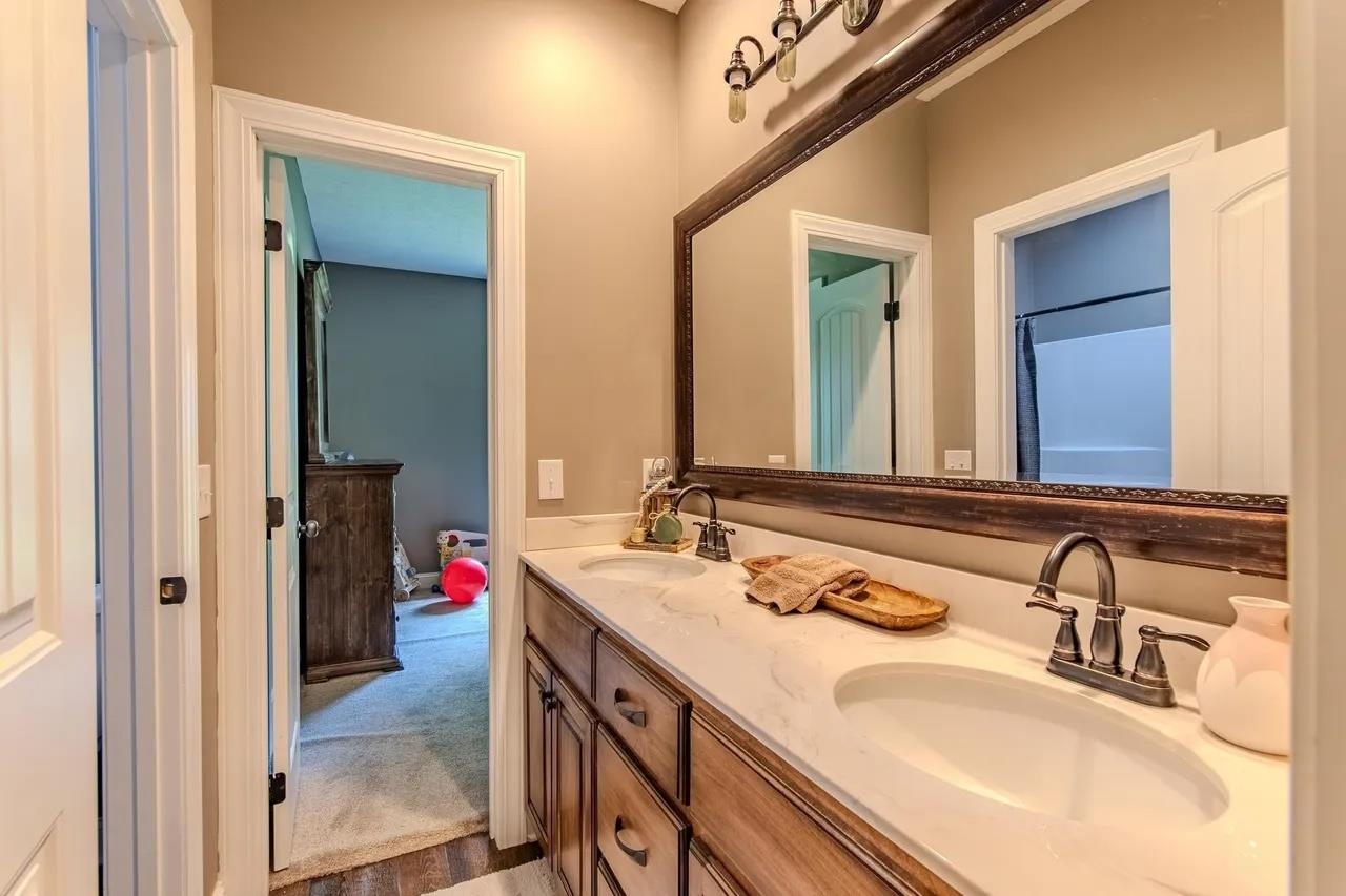 2134 Otis Plunk Road Bethel Springs, TN 38315 - Photo 20 of 35 a bathroom with a granite countertop double vanity sink and a mirror