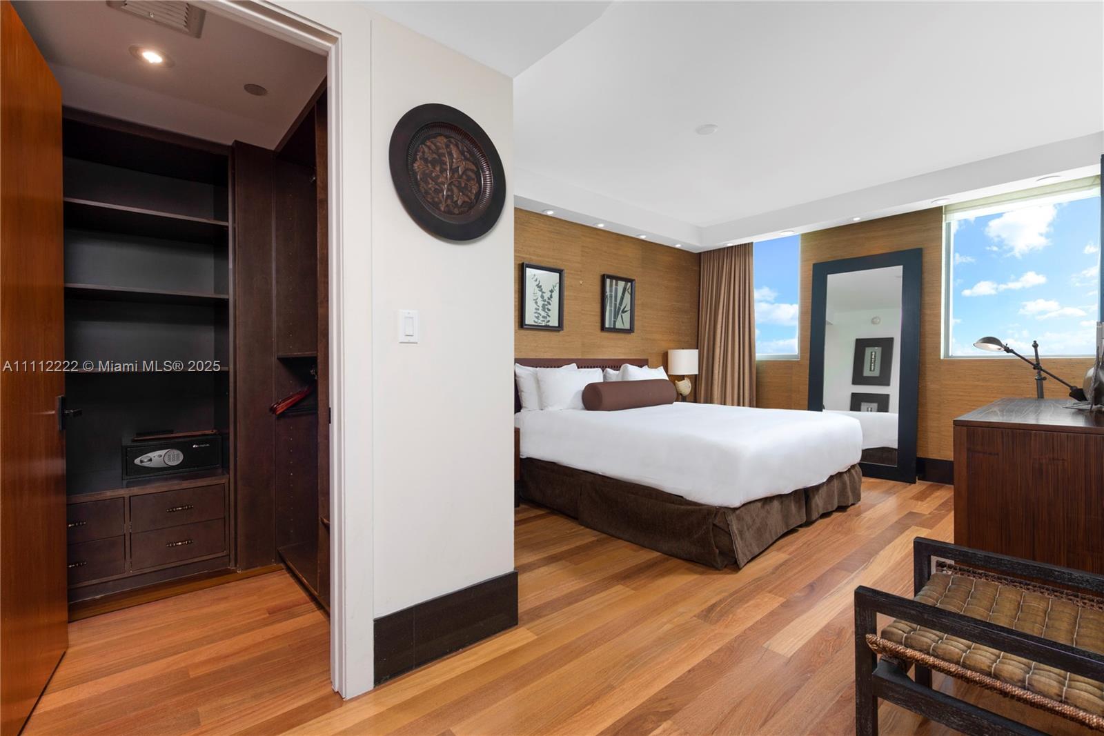 101 20th Street, Unit 2402 Miami Beach, FL 33139 - Photo 11 of 23 a bedroom with a bed and a bookshelf with wooden floor