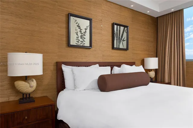 a bedroom with a bed and painting on the wall